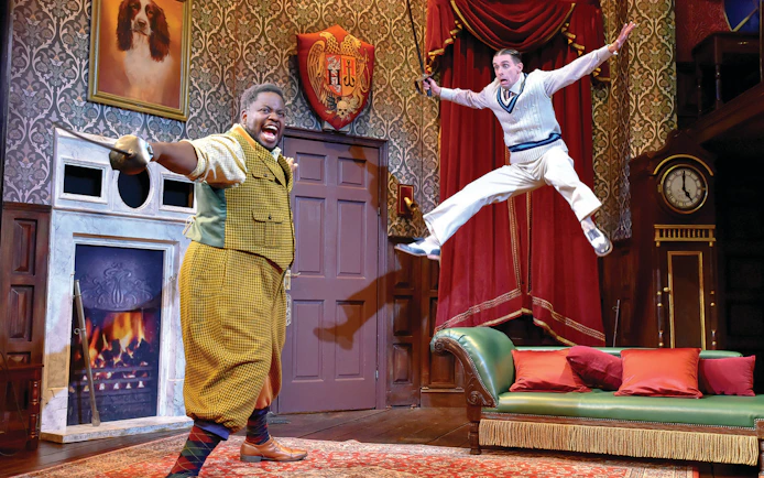 Actors performing a comedic scene in "The Play That Goes Wrong" on stage.