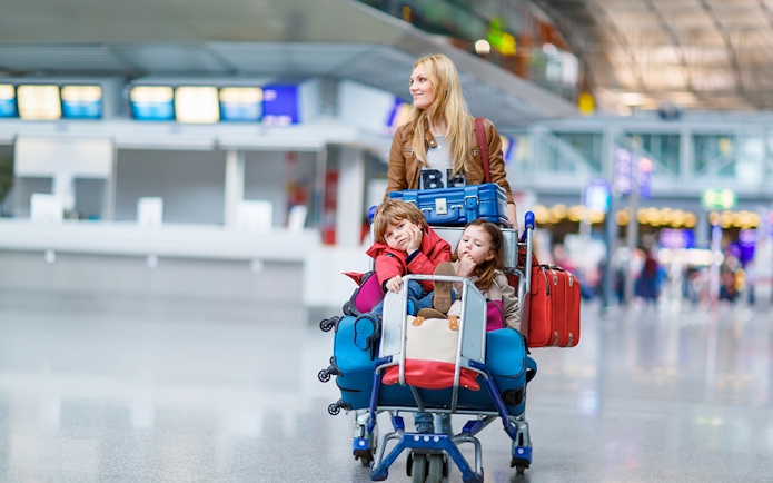 Family with luggage at airport, ready for shuttle service to Disneyland Paris from CDG/ORY.