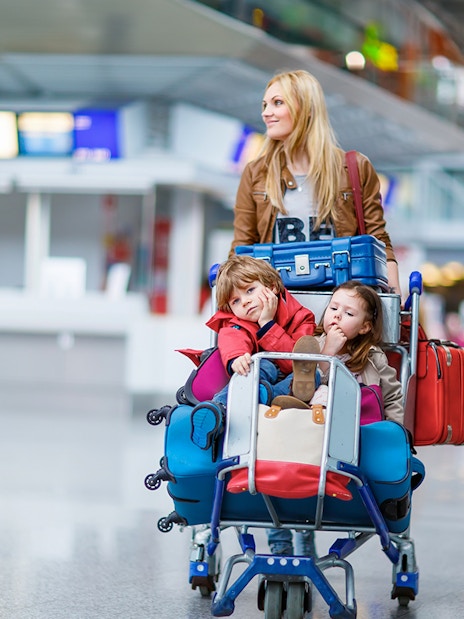 Family with luggage at airport, ready for shuttle service to Disneyland Paris from CDG/ORY.