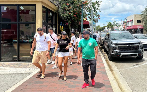 Guests exploring Miami city tour with iconic Art Deco architecture in the background.