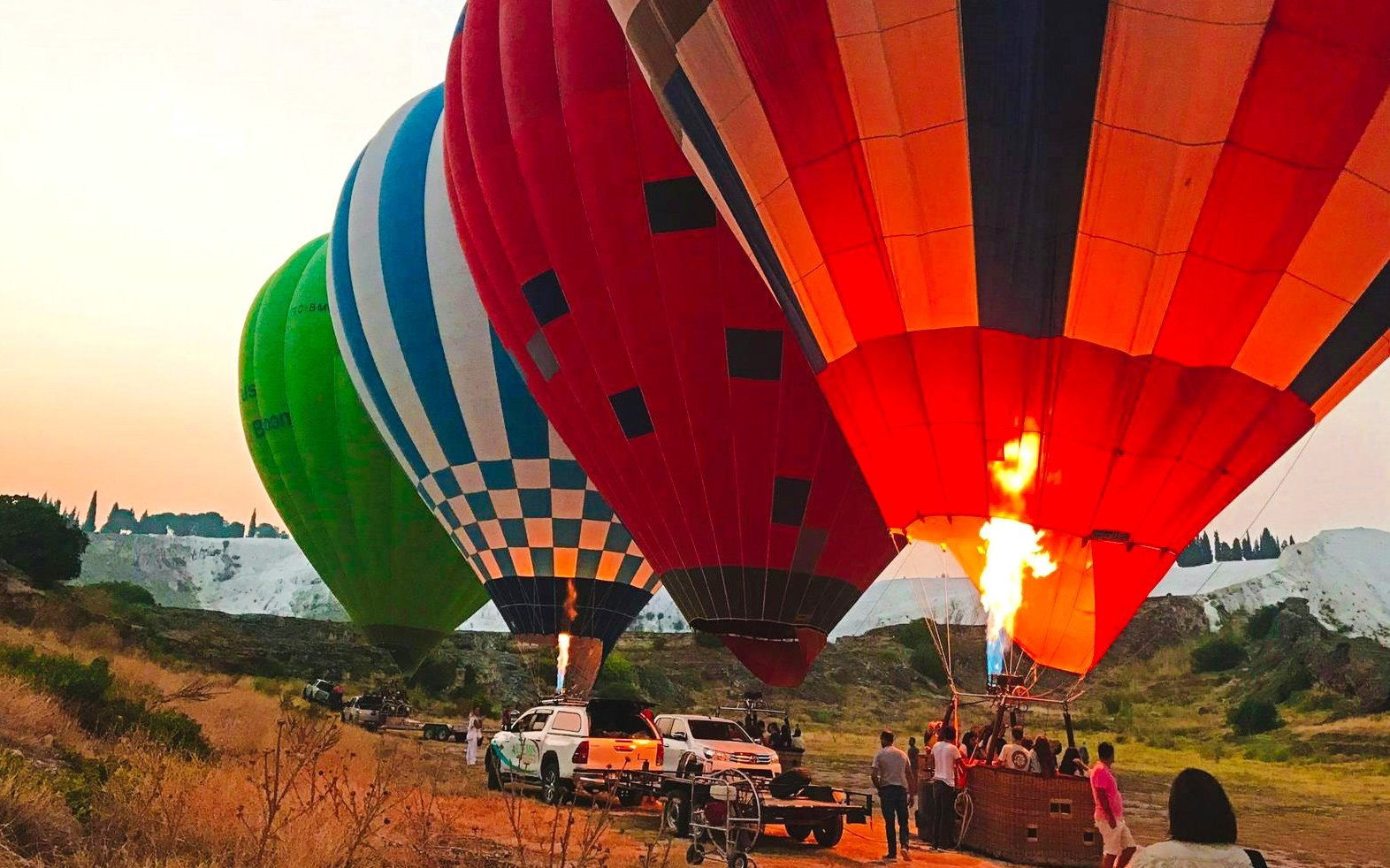 Hot air balloons preparing for flight at sunrise in Pamukkale, Turkey.