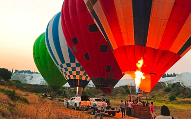 Hot air balloons preparing for flight at sunrise in Pamukkale, Turkey.