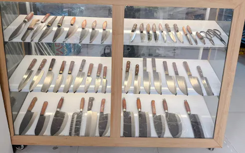 Knives displayed in a glass cabinet at a Hanoi knife-making workshop in a 400-year-old blacksmith village.