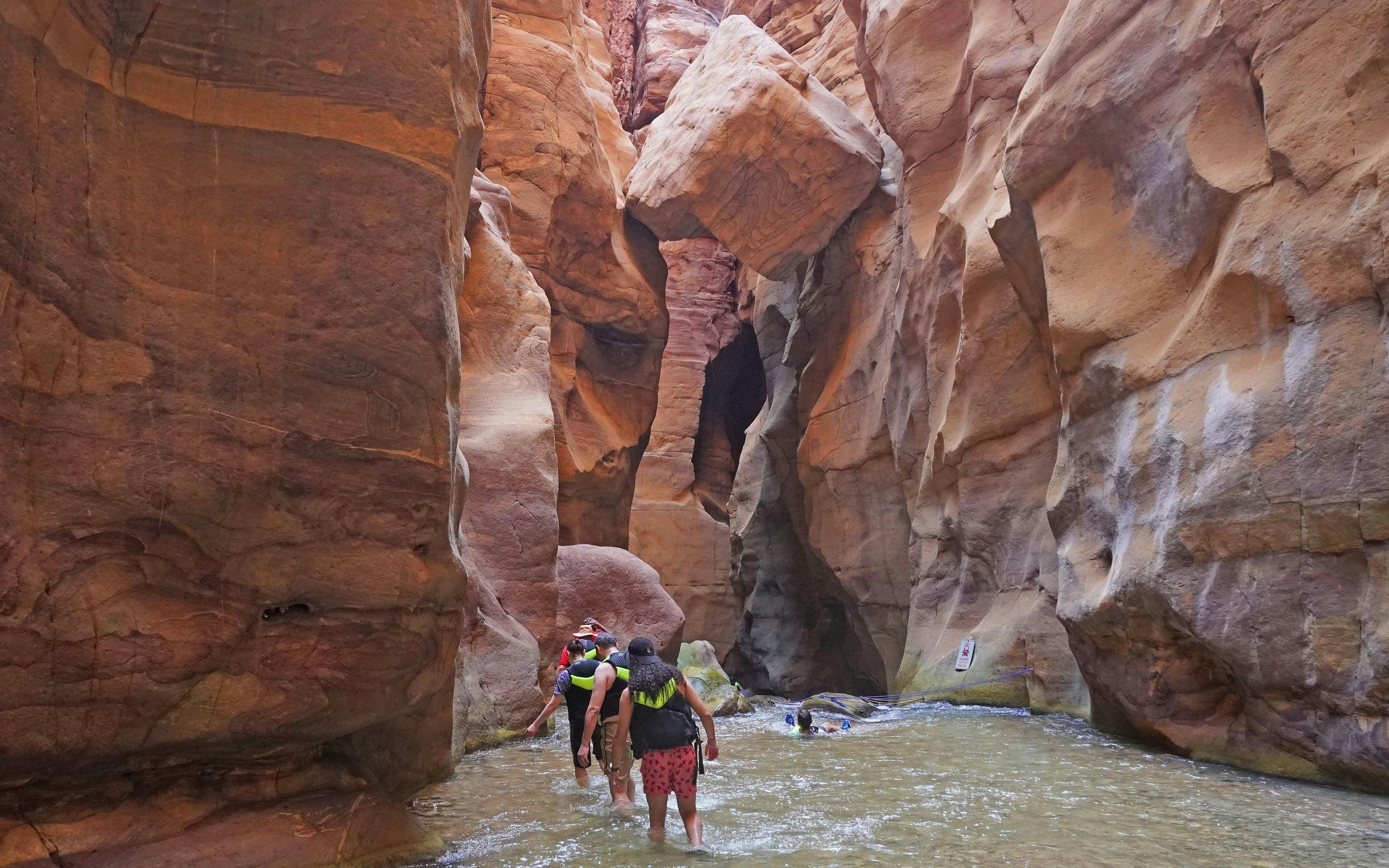 Tourists hiking through Wadi Mujib gorge in Jordan.