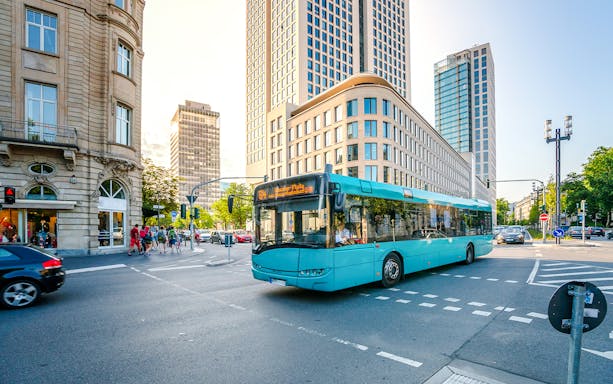 City bus on a street in Frankfurt am Main with modern buildings in the background.