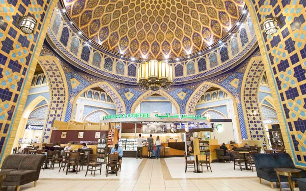 Starbucks inside ornate terminal at Abu Dhabi Airport, featuring intricate tilework.