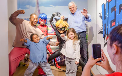 Visitors posing with superhero wax figures at Grévin Paris Wax Museum.