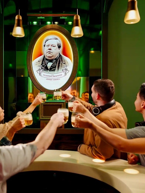 Visitors toasting with beer at the Pilsner Urquell Experience in Prague.