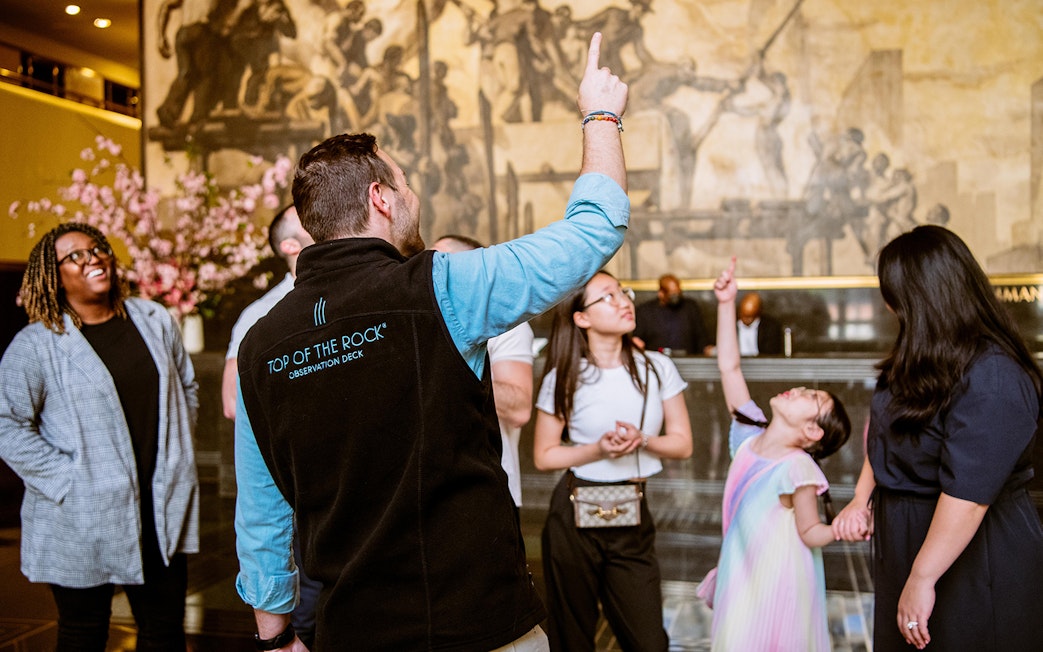 Tour guide leading a group at Rockefeller Center, New York City.