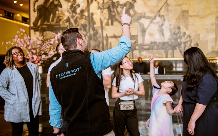 Tour guide leading a group at Rockefeller Center, New York City.