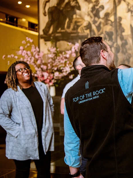 Tour guide leading a group at Rockefeller Center, New York City.