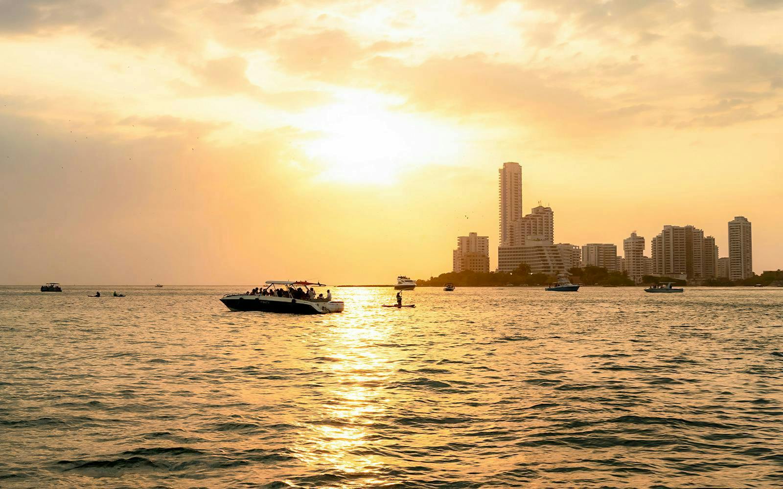 Sunset over Cartagena skyline with boats on the water, Colombia.