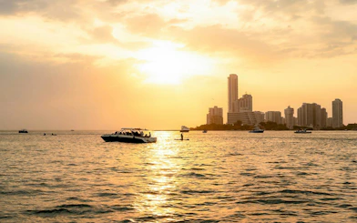 Sunset over Cartagena skyline with boats on the water, Colombia.