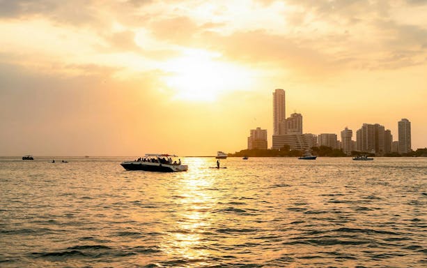 Sunset over Cartagena skyline with boats on the water, Colombia.
