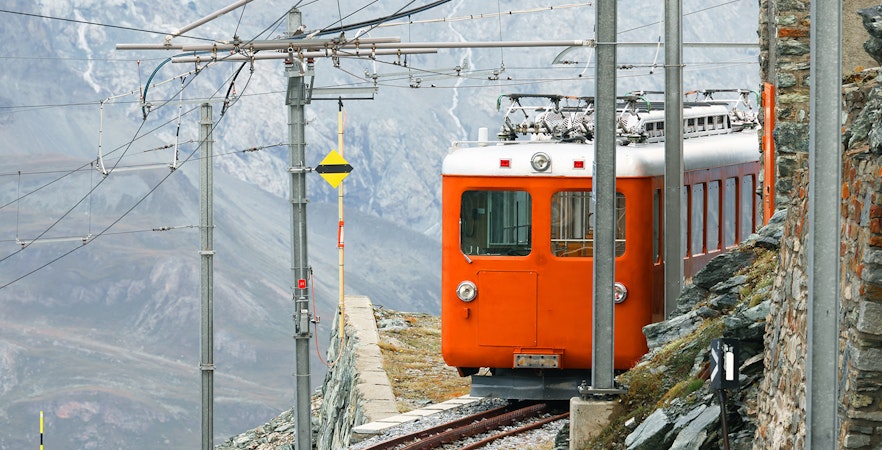 Historic Gornergrat Railway train on mountain track in the Swiss Alps.