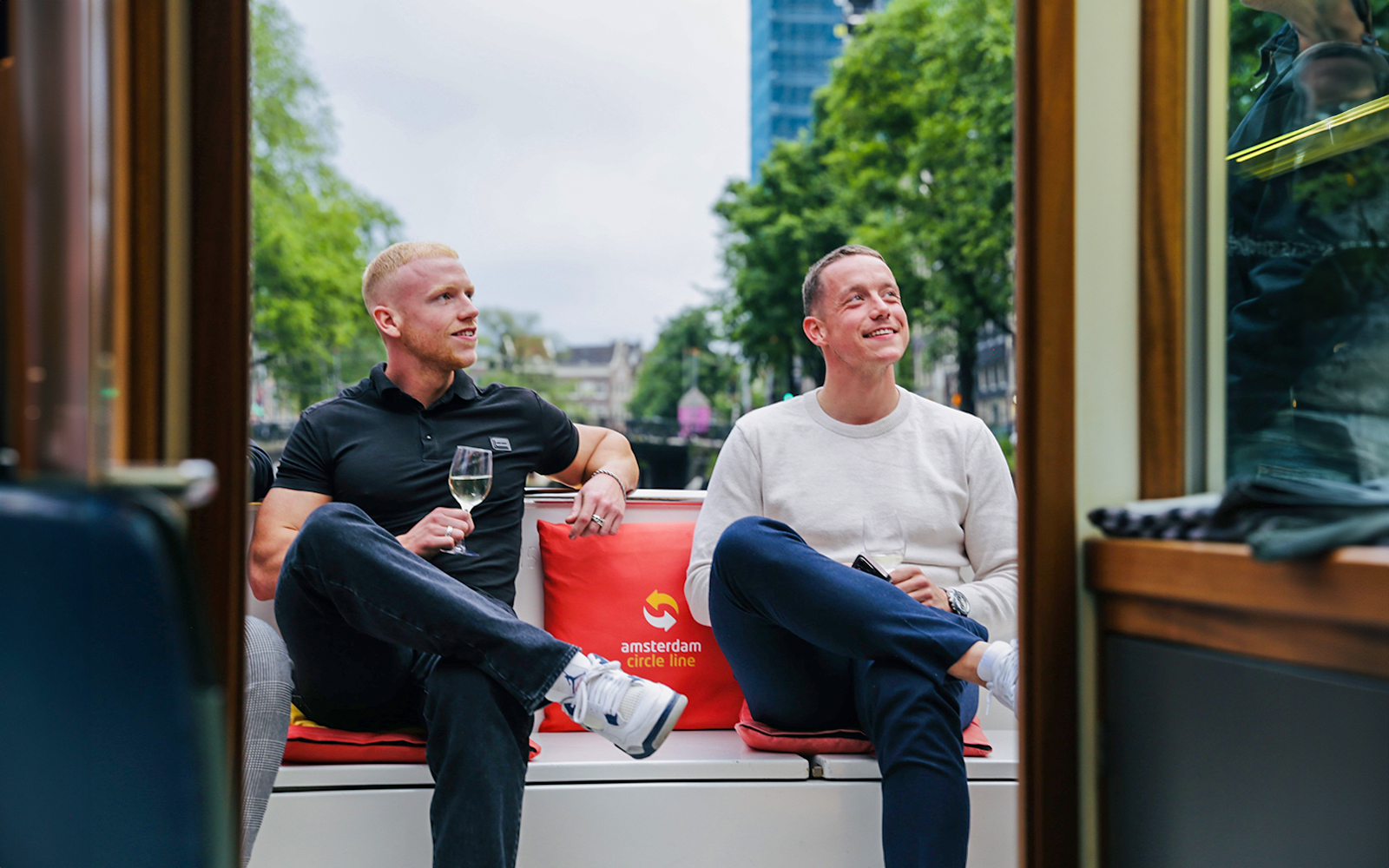Two people enjoying wine on an Amsterdam canal cruise.