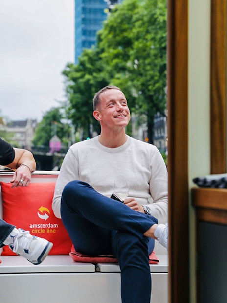 Two people enjoying wine on an Amsterdam canal cruise.
