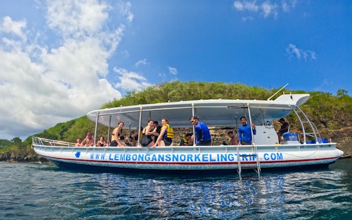 Snorkeling boat with tourists near Nusa Lembongan, Indonesia, on a sunny day.