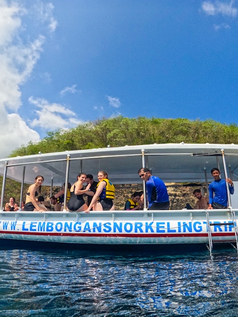 Snorkeling boat with tourists near Nusa Lembongan, Indonesia, on a sunny day.