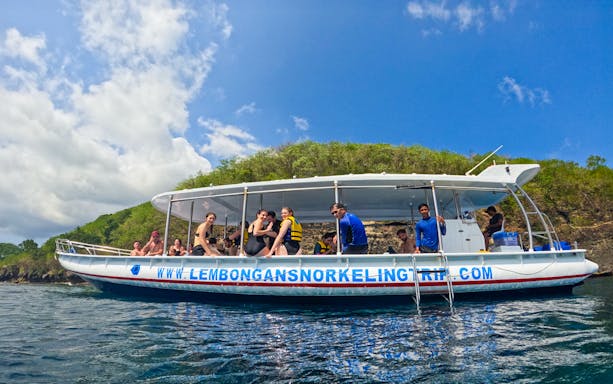 Snorkeling boat with tourists near Nusa Lembongan, Indonesia, on a sunny day.