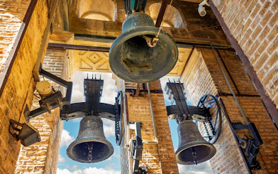 Bells of the Giralda tower in Seville, Spain against a blue sky.