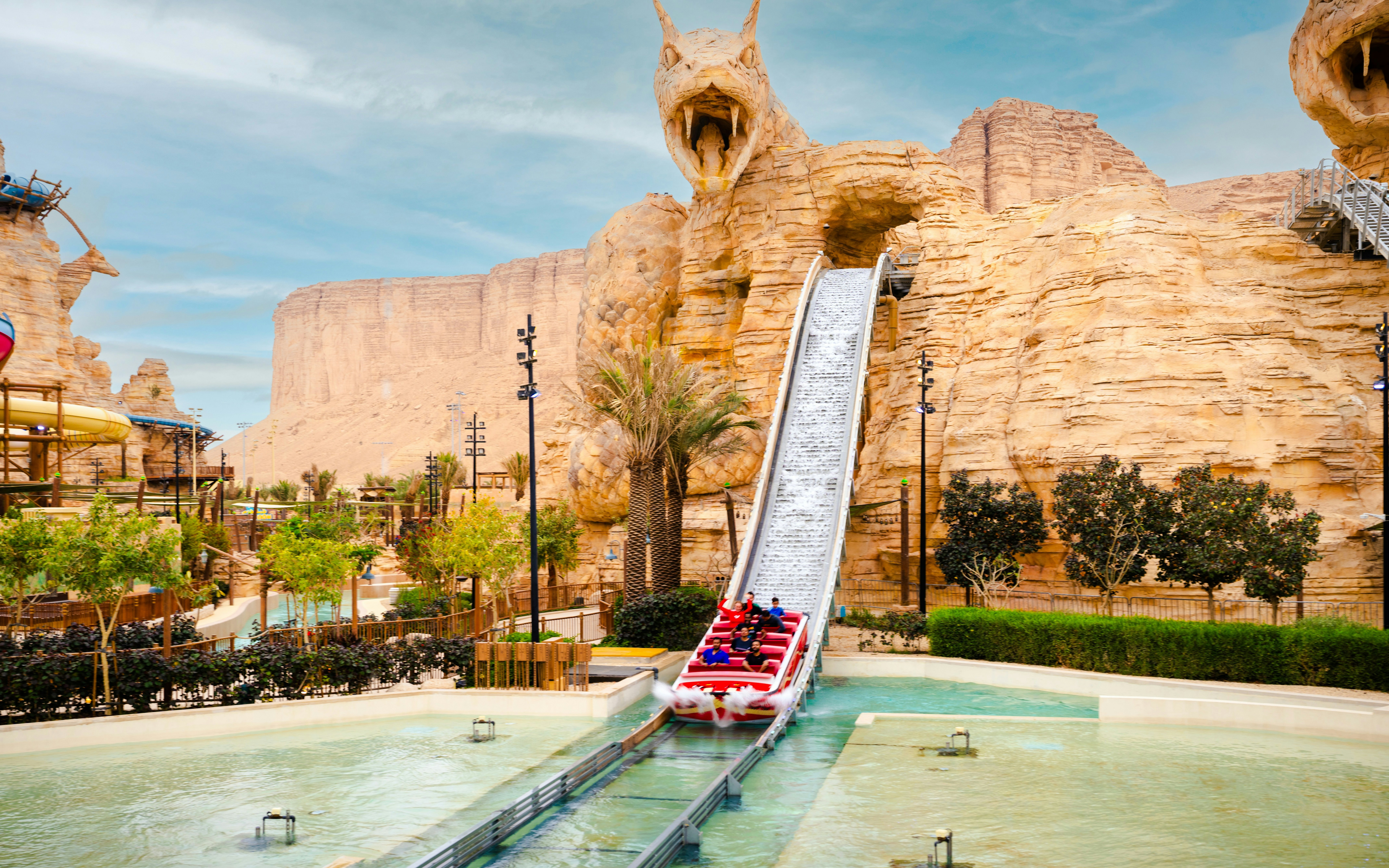 Water ride descending from dragon-themed slide at Aquarabia Water Theme Park, Qiddiya City, Saudi Arabia.