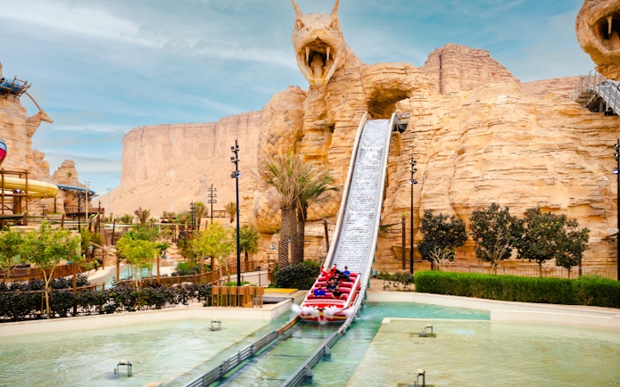 Water ride descending from dragon-themed slide at Aquarabia Water Theme Park, Qiddiya City, Saudi Arabia.