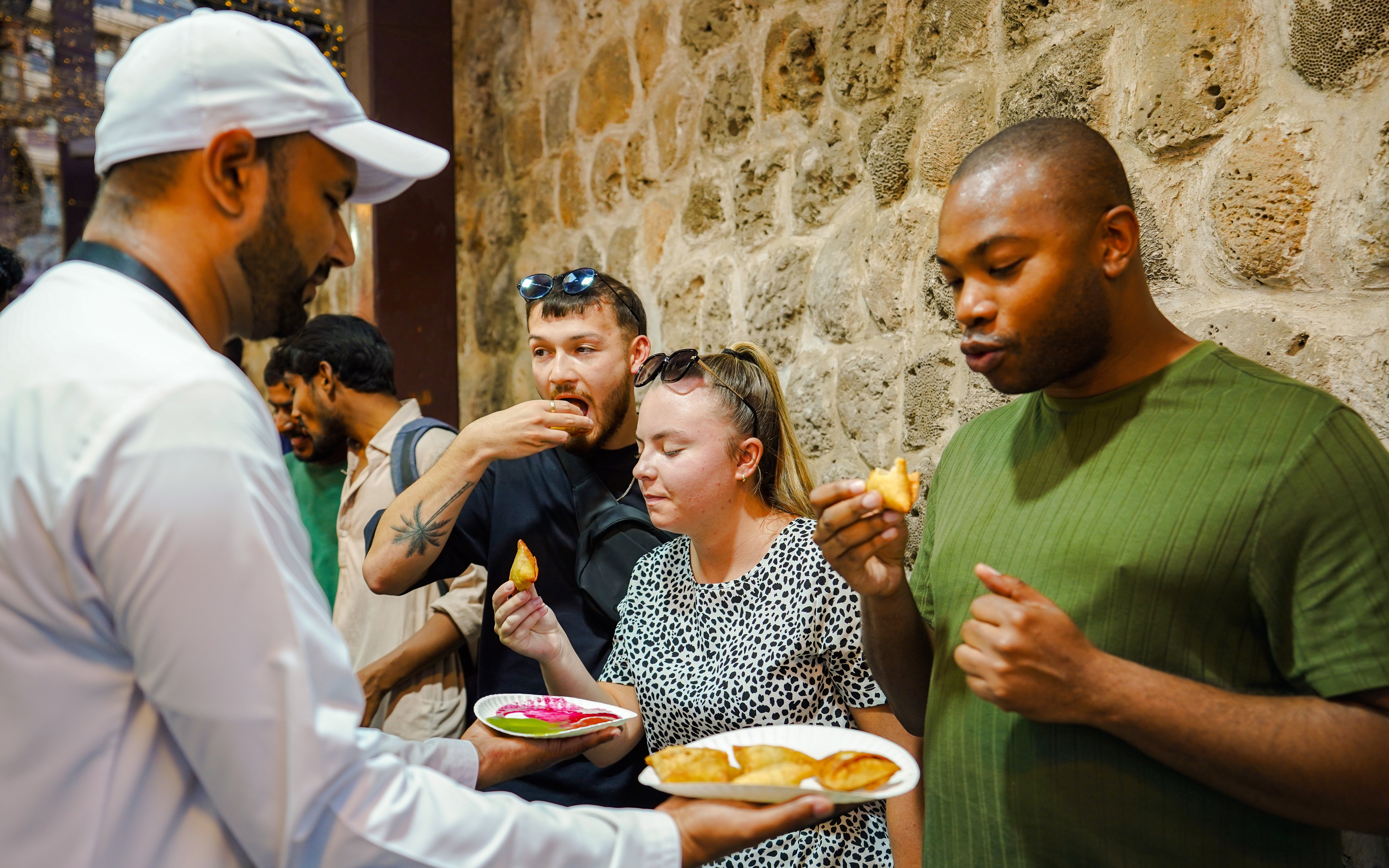 Visitors enjoying street food tasting experience.