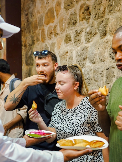 Visitors enjoying street food tasting experience.