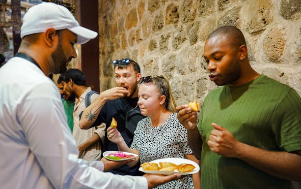 Visitors enjoying street food tasting experience.