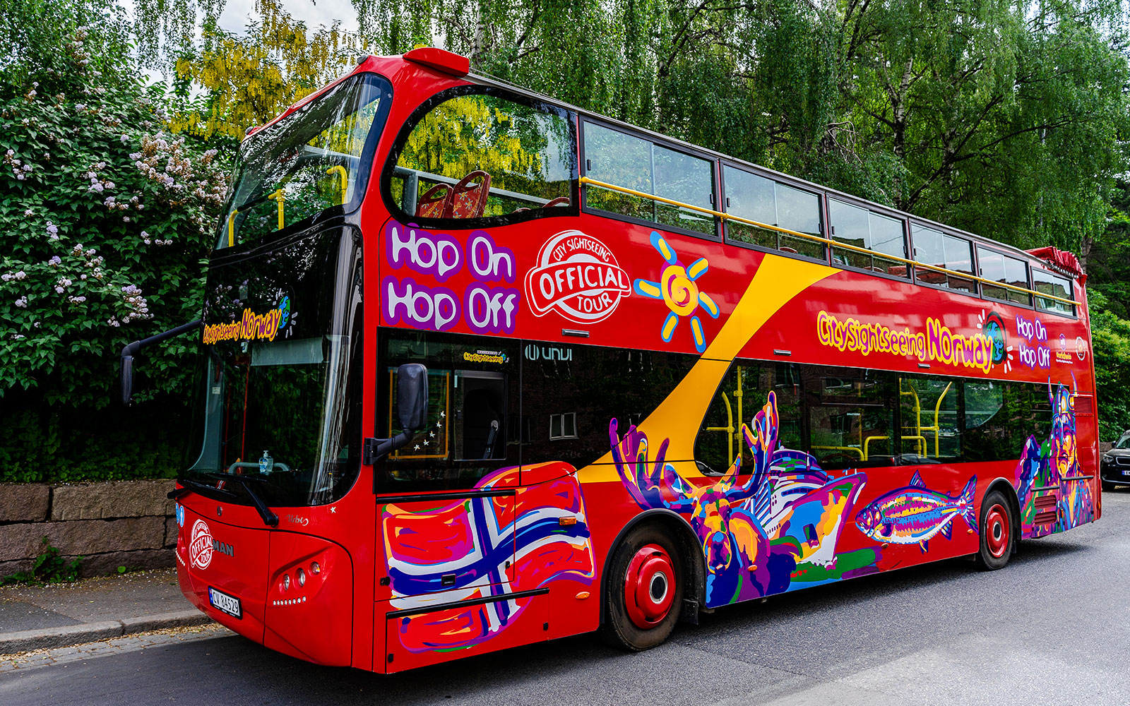Stavanger hop-on hop-off tour bus with colorful design parked on a street.