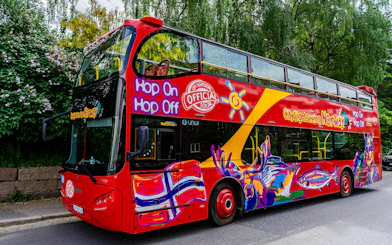 Stavanger hop-on hop-off tour bus with colorful design parked on a street.