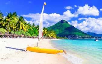 Transparent kayak on Flic en Flac Beach, Mauritius, with Le Morne Brabant in the background.