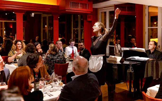 Opera singer performing at Bel Canto restaurant in Paris during dinner show.