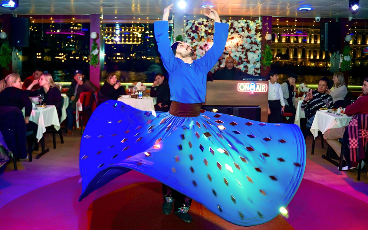 Dervish dancer performing on Bosphorus Dinner Cruise with audience watching.