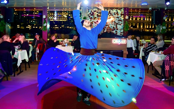 Dervish dancer performing on Bosphorus Dinner Cruise with audience watching.