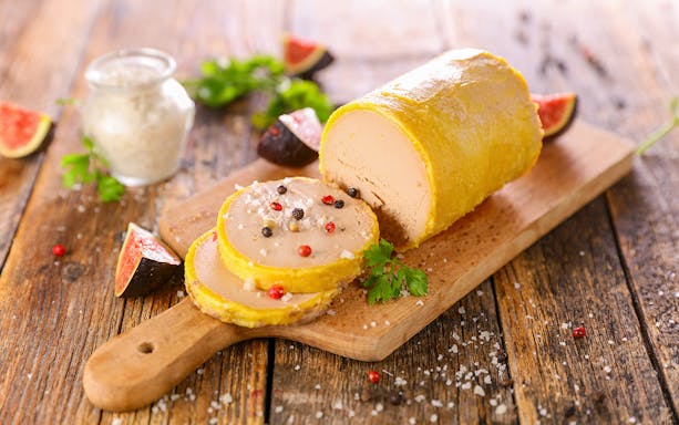 Foie gras with figs and peppercorns on a wooden board, Paris Saint Germain food tour.