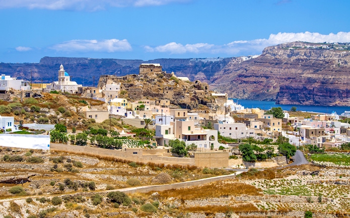 Traditional village near Akrotiri on Santorini island with whitewashed buildings and sea view.