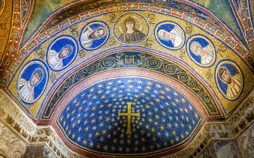Ravenna mosaic depicting religious figures and a starry sky in a historic monument.