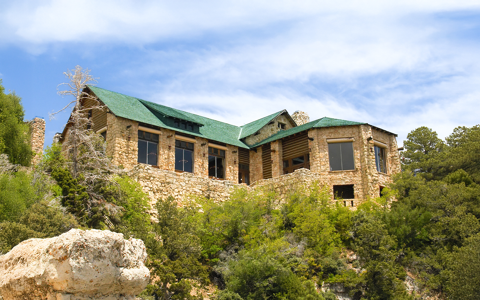 Grand Canyon lodge with desert bushes in foreground, showcasing natural landscape.