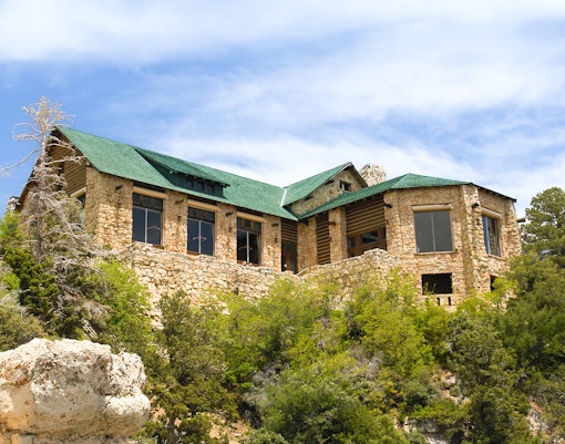 Grand Canyon lodge with desert bushes in foreground, showcasing natural landscape.
