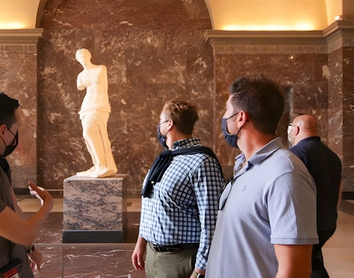 Tourists viewing the winged victory at the Louvre Museum, Paris.