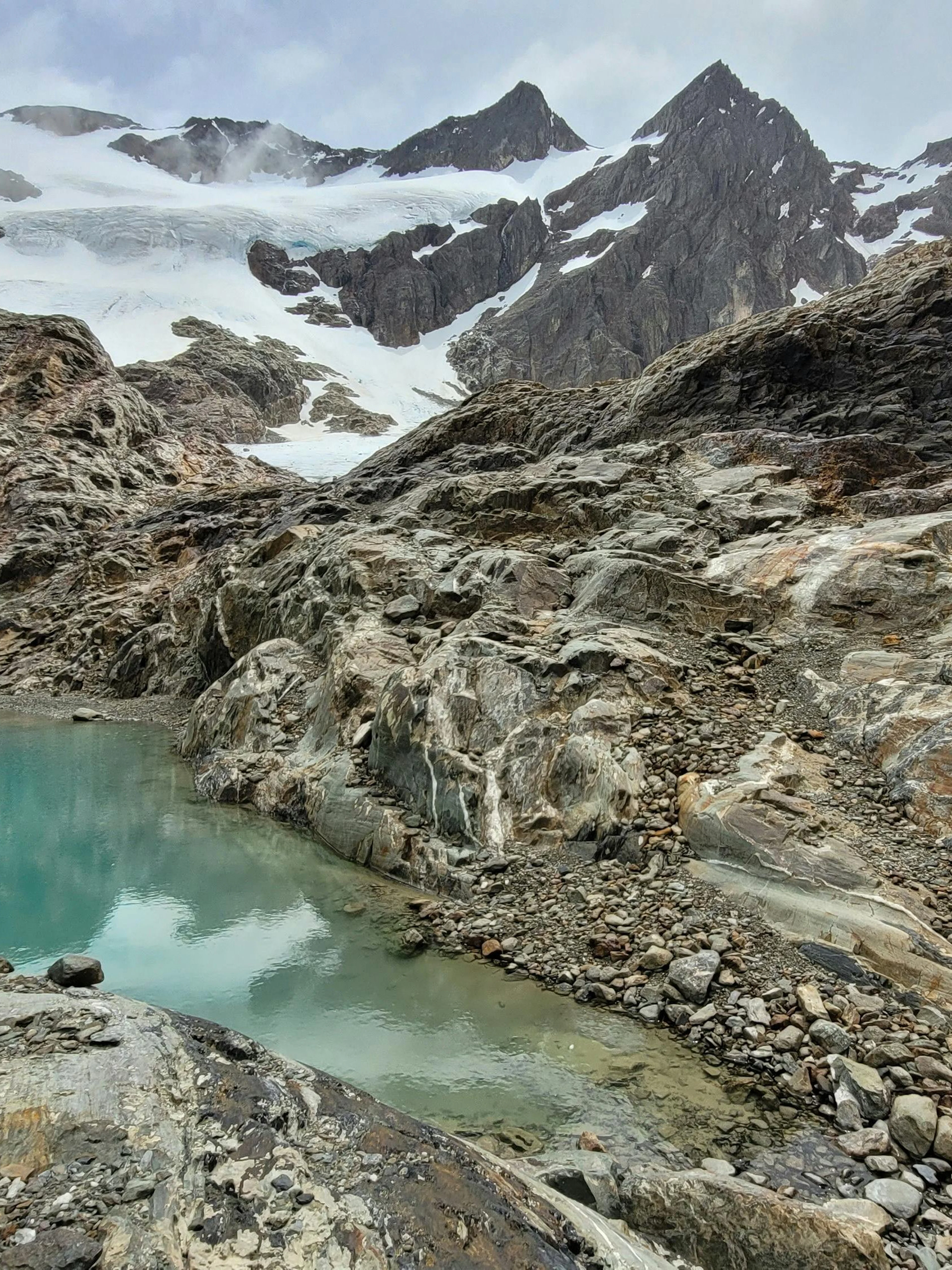Vinciguerra Glacier with turquoise lagoon and rocky terrain in Ushuaia, Argentina.