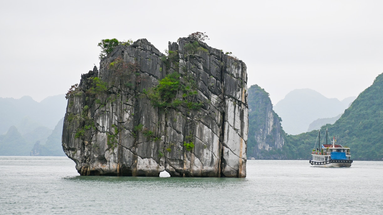 Dinh Huong Islet in Ha Long Bay, Vietnam, surrounded by emerald waters and limestone formations.