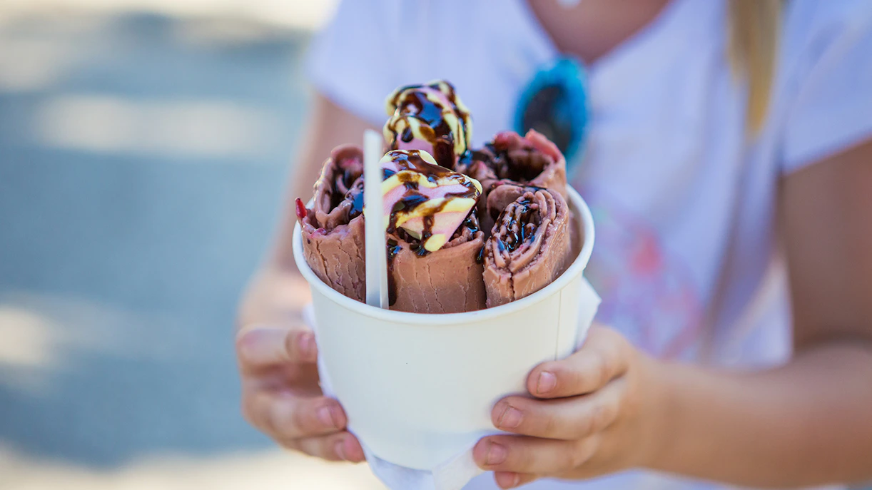 Chocolate ice cream roll on a white plate, showcasing a dessert experience.