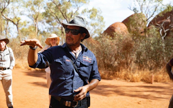 Tour guide explaining Uluru's history during a full-day tour from Alice Springs.