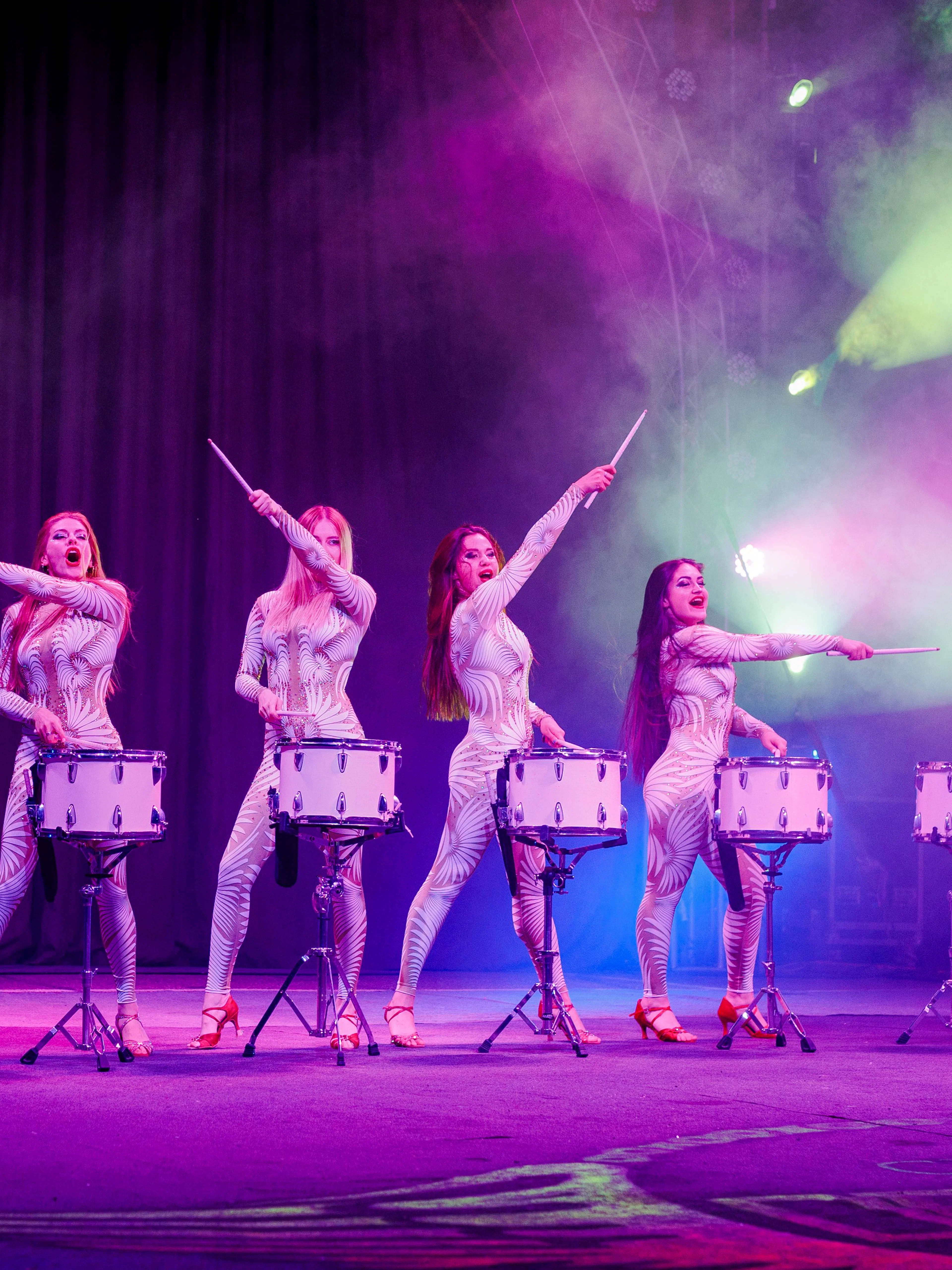 Drummers performing at Aqua Circus Phuket with vibrant stage lighting.