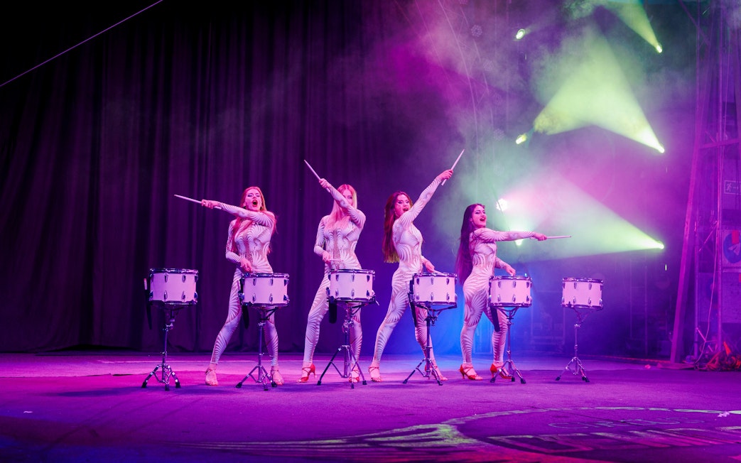Drummers performing at Aqua Circus Phuket with vibrant stage lighting.