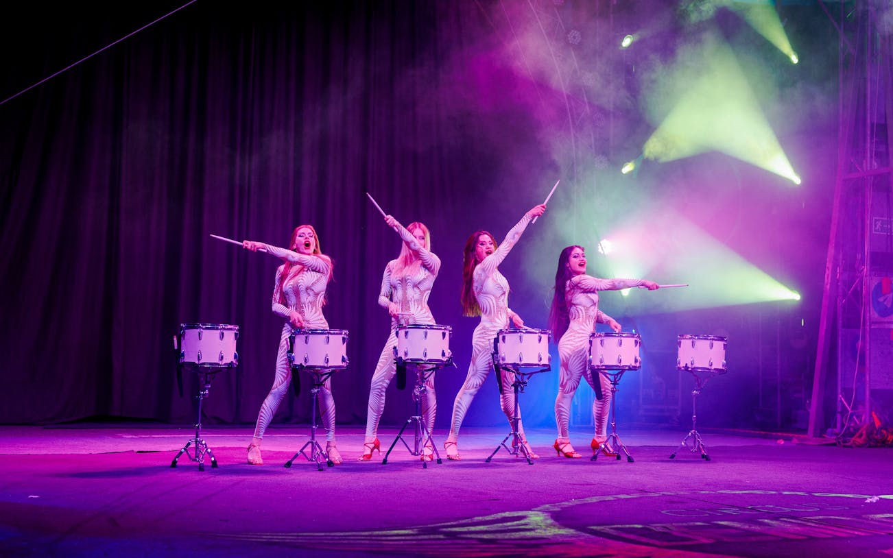 Drummers performing at Aqua Circus Phuket with vibrant stage lighting.