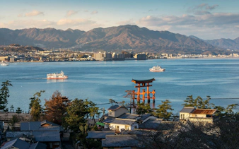 Great Floating Gate O Torii on Miyajima Island, Japan, with ferries in the Seto Inland Sea.